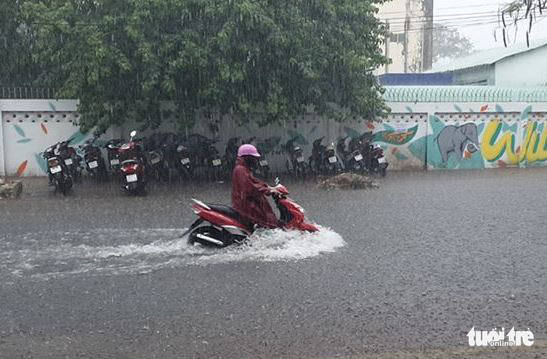 A motorcyclist struggles through floodwater after a downpour in Ca Mau City, Ca Mau Province, Vietnam, March 10, 2020. Photo: Thanh Minh / Tuoi Tre