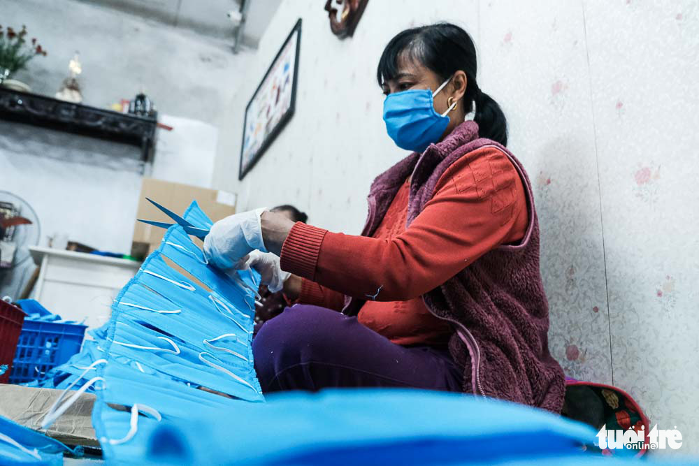 A member of Hai Boi Women’s Union helps separate face masks at a raincoat factory in Dong Anh District, Hanoi, Vietnam. Photo: Mai Thuong / Tuoi Tre