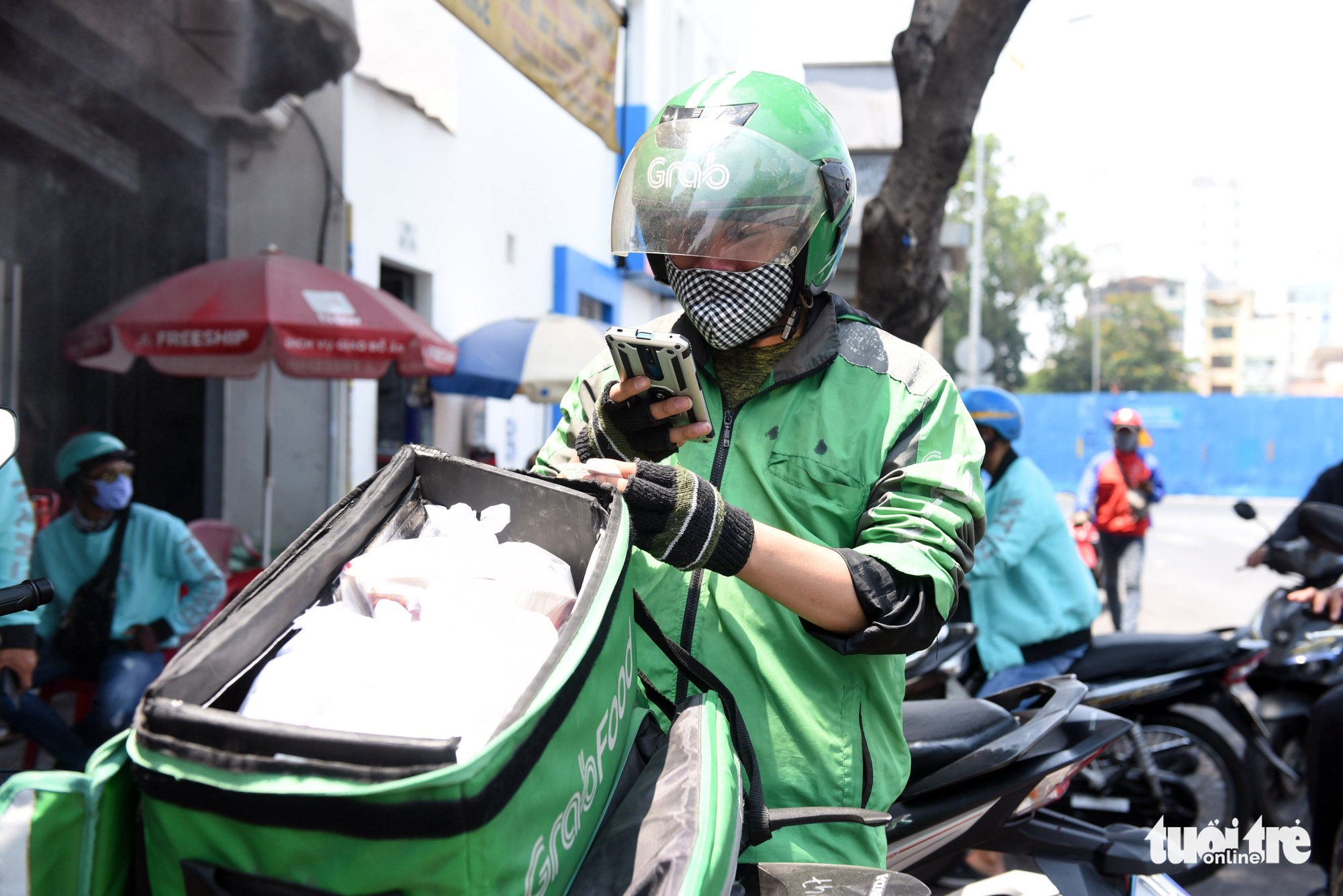 A Grab driver takes a photo of a restaurant bill before delivering food to customers in Ho Chi Minh City, Vietnam. Photo: Duyen Phan / Tuoi Tre