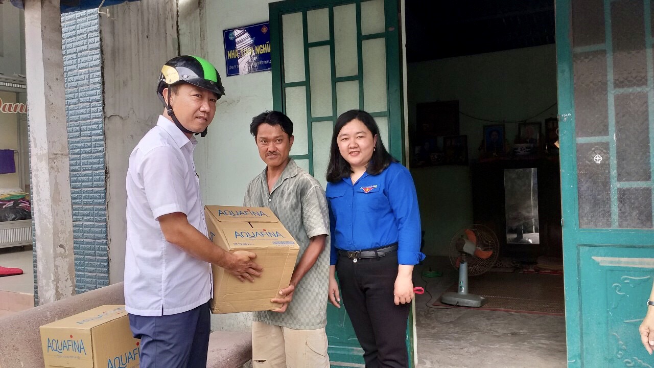 A Ben Tre Youth Union official (left) hands bottled water  donated by Suntory PepsiCo Vietnam to a household in Ben Tre Province, Vietnam, March 9, 2020.