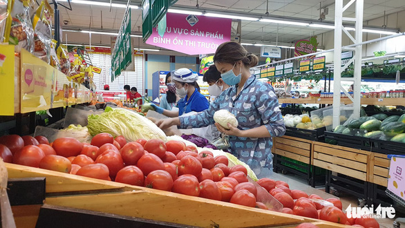 <em>People wearing face masks shop for vegetables at a supermarket in Ho Chi Minh City, Vietnam, March 31, 2020. Photo:</em> Bong Mai / Tuoi Tre