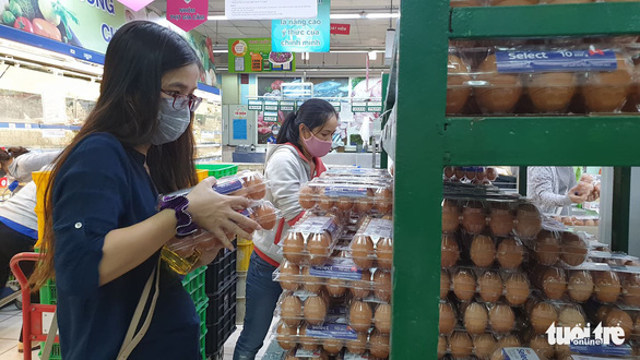<em>Two women wearing face masks shop for eggs at a supermarket in Ho Chi Minh City, Vietnam, March 31, 2020. Photo:</em> Bong Mai / Tuoi Tre