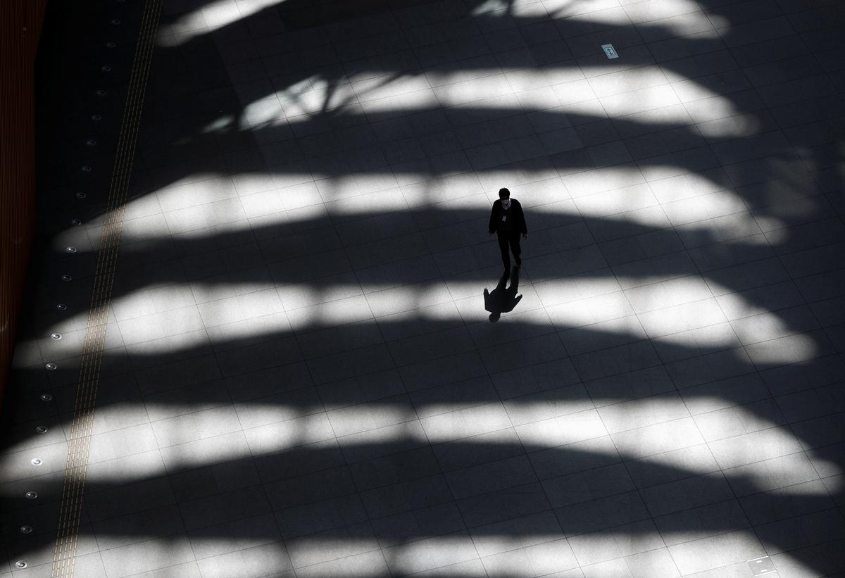 A man wearing a protective face mask, following an outbreak of the coronavirus disease (COVID-19), walks past inside an almost empty convention complex in Tokyo, Japan April 6, 2020. Photo: Reuters