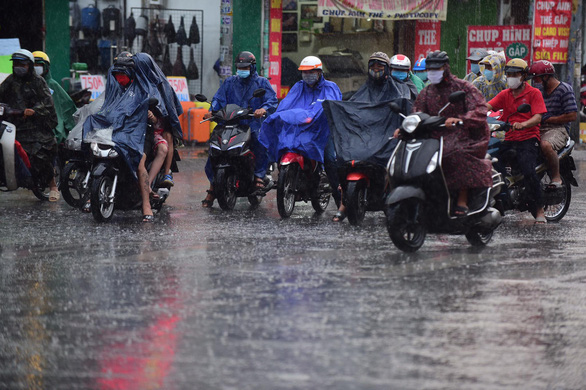 People ride motorbikes in the rain on Au Co Street in Tan Phu District, Ho Chi Minh City, April 9, 2020. Photo: Quang Dinh / Tuoi Tre