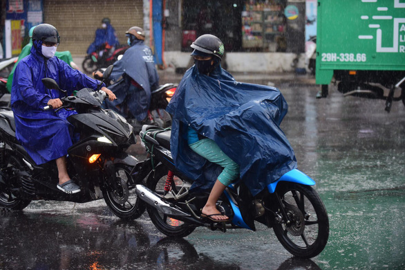 People ride motorbikes in the rain on Au Co Street in Tan Phu District, Ho Chi Minh City, April 9, 2020. Photo: Quang Dinh / Tuoi Tre