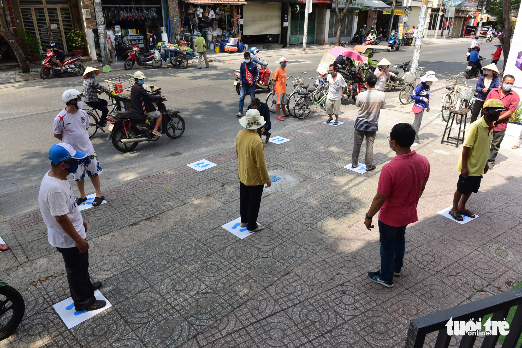Those who wish to use the 'rice ATM' in Tan Phu District, Ho Chi Minh City, Vietnam must stand on labels placed two meters apart. Photo: Quang Dinh / Tuoi Tre