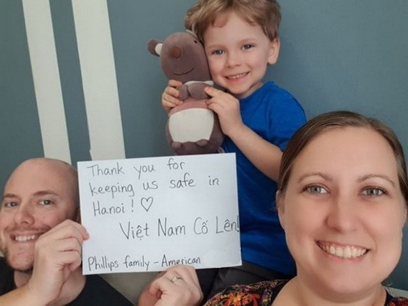 American expats Joe and Becca Phillips and their son, Scotty, pose for a photo with a thank-you message to Vietnam’s frontline forces in the COVID-19 battle in this picture uploaded to the Hanoi Massive Community Facebook group on April 13, 2020.