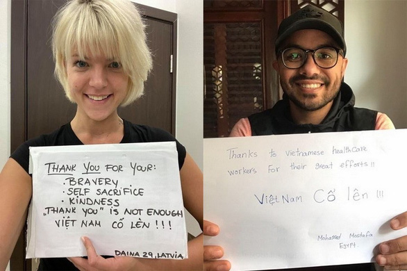 Latvia's Daina Raiskuma (left) and Mohamed Mostafa Shaaban from Egypt pose for photos with their grateful messages to Vietnam’s frontline forces in the COVID-19 battle in these supplied pictures.