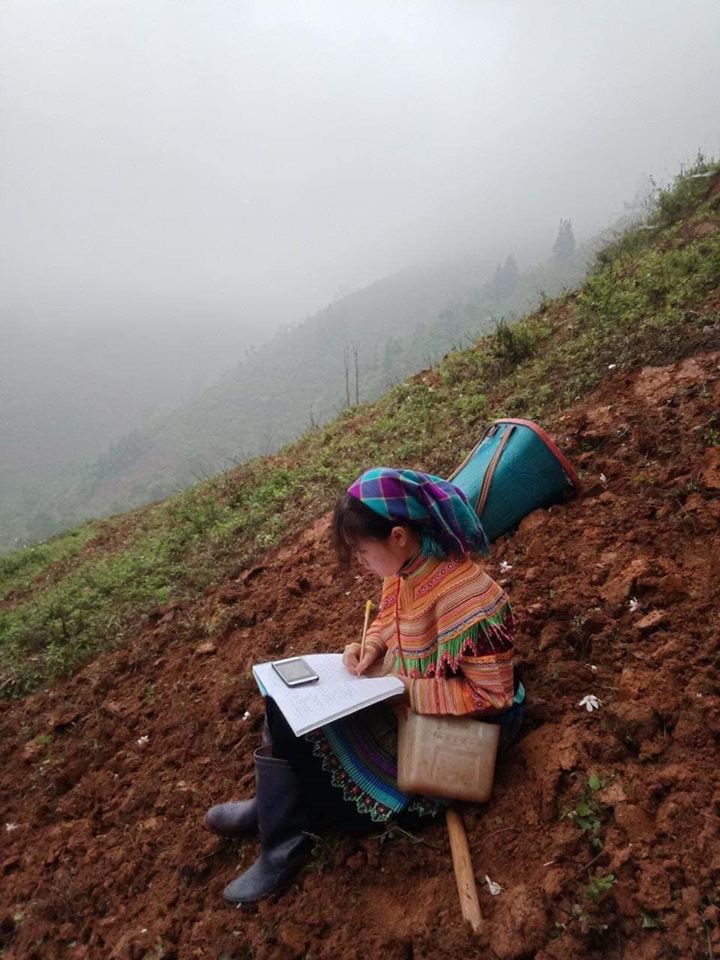 Vang Thi Xa, a member of the Mong ethnic minority group in Si Ma Cai District, Lao Cai Province, Vietnam, is seen studying during a break from her work on a family farm.