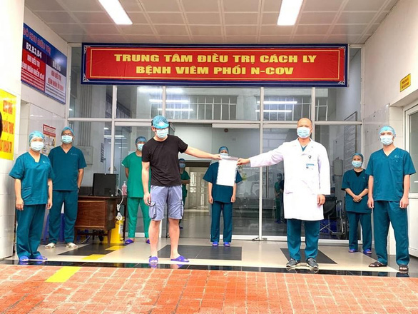 Vietnam’s COVID-19 patient No. 149 (left) receives a hopital discharge certificate in Ha Nam Province in this supplied photo taken on April 16, 2020.