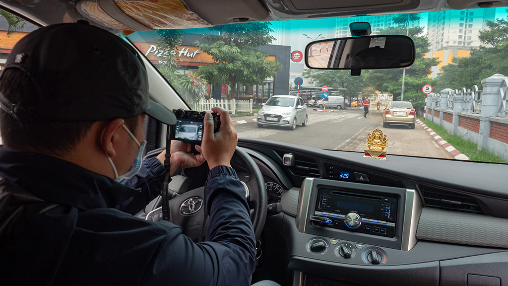 A detective in Vietnam take photos of his subject from a car. Photo: V.Tuan / Tuoi Tre