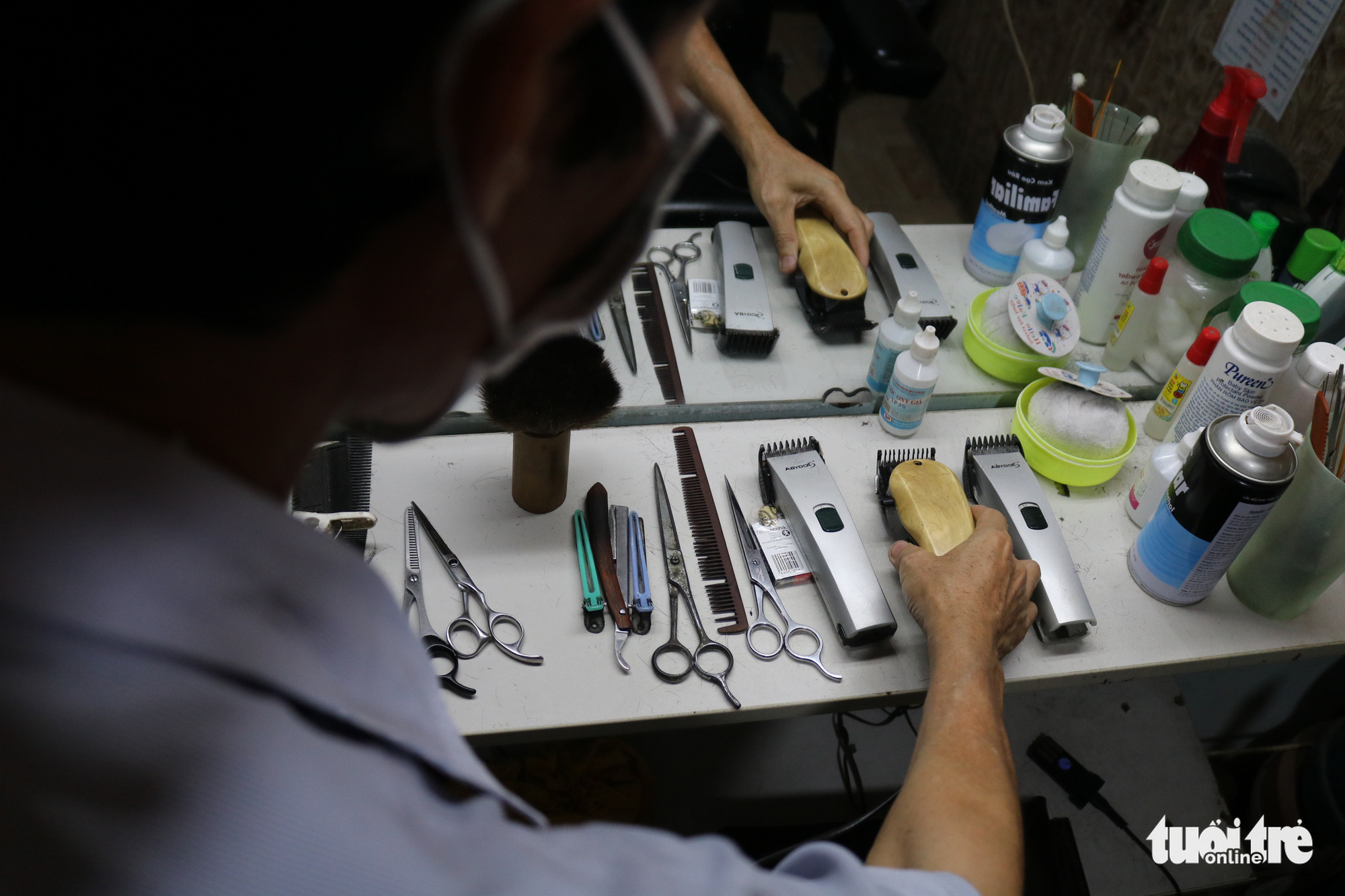 A barber organizes his tools to prepare for reopening after the announcement of eased social distancing measures in Ho Chi Minh City, Vietnam, April 22, 2020. Photo: Ngoc Phuong / Tuoi Tre