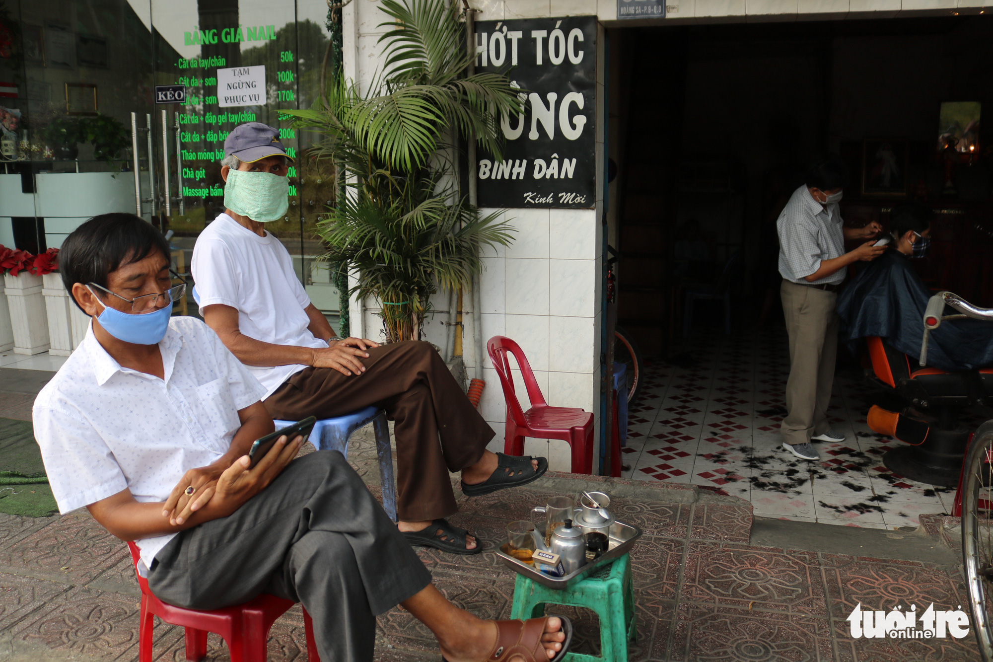Customers wait for a haircut outside a barbershop in Ho Chi Minh City, Vietnam, April 23, 2020. Photo: Ngoc Phuong / Tuoi Tre
