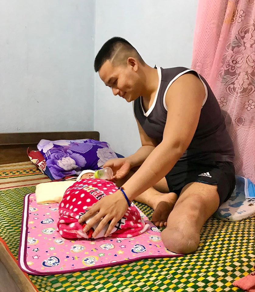 Luu Nguyen cares for an orphaned baby in this supplied photo.