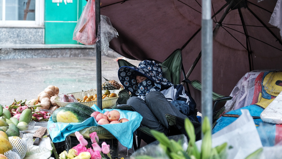 A woman takes a nap while selling fruits on the street after COVID-19 social distancing measures were relaxed in Hanoi, Vietnam. Photo: Mai Thuong / Tuoi Tre