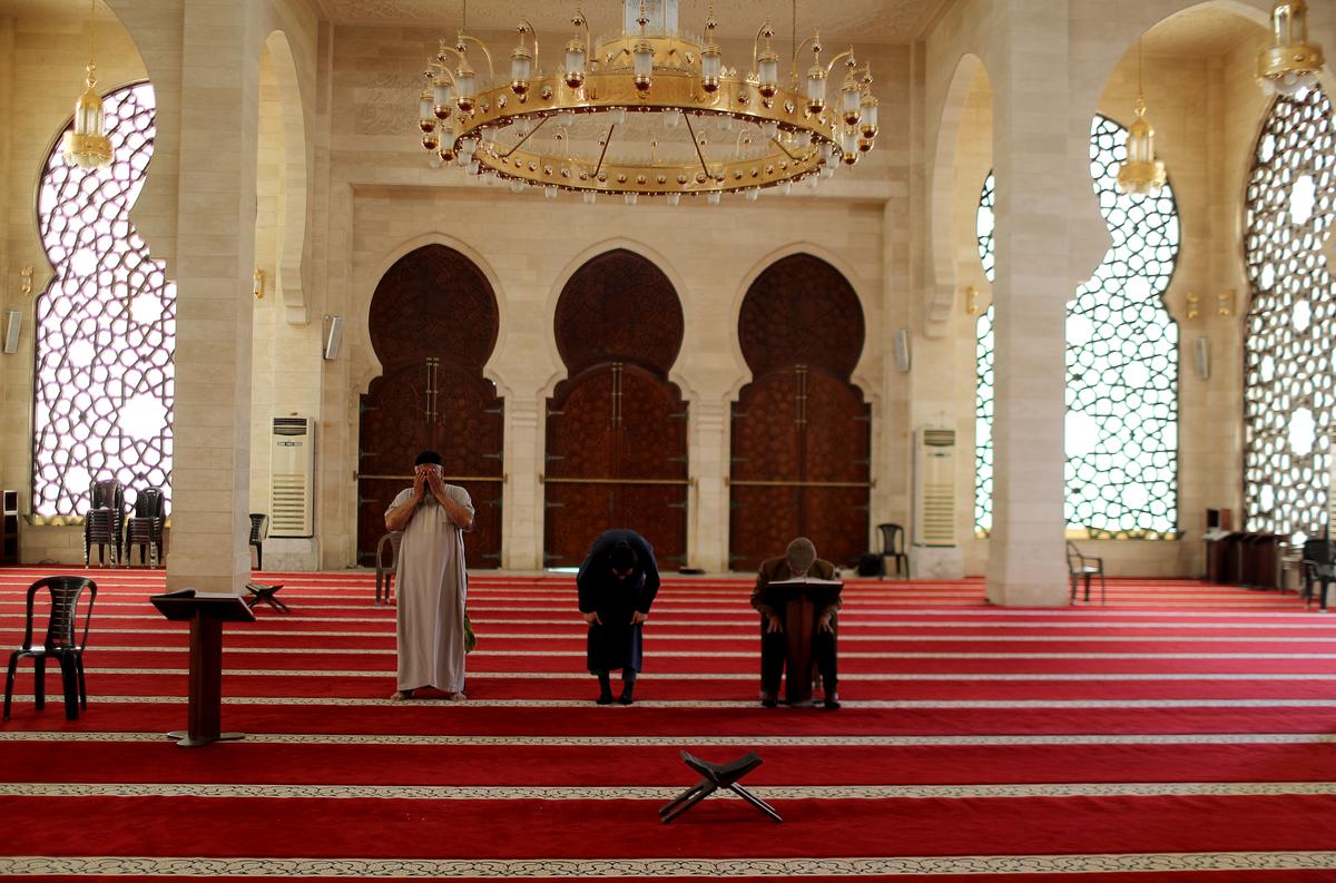 Palestinian mosque keepers pray in an almost empty mosque on the first Friday of the holy fasting month of Ramadan as prayers by worshippers in the holy places are suspended due to concerns about the spread of the coronavirus disease (COVID-19) in the northern Gaza Strip April 24, 2020. Photo: Reuters