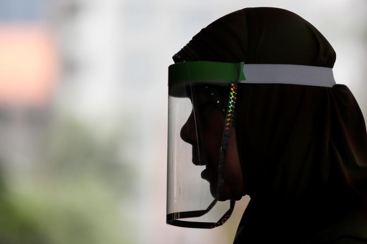 A Muslim woman wearing a face shield prays at a mosque on the first day of holy fasting month of Ramadan, amid the coronavirus disease (COVID-19) outbreak, in Bangkok, Thailand April 24, 2020. Photo: Reuters