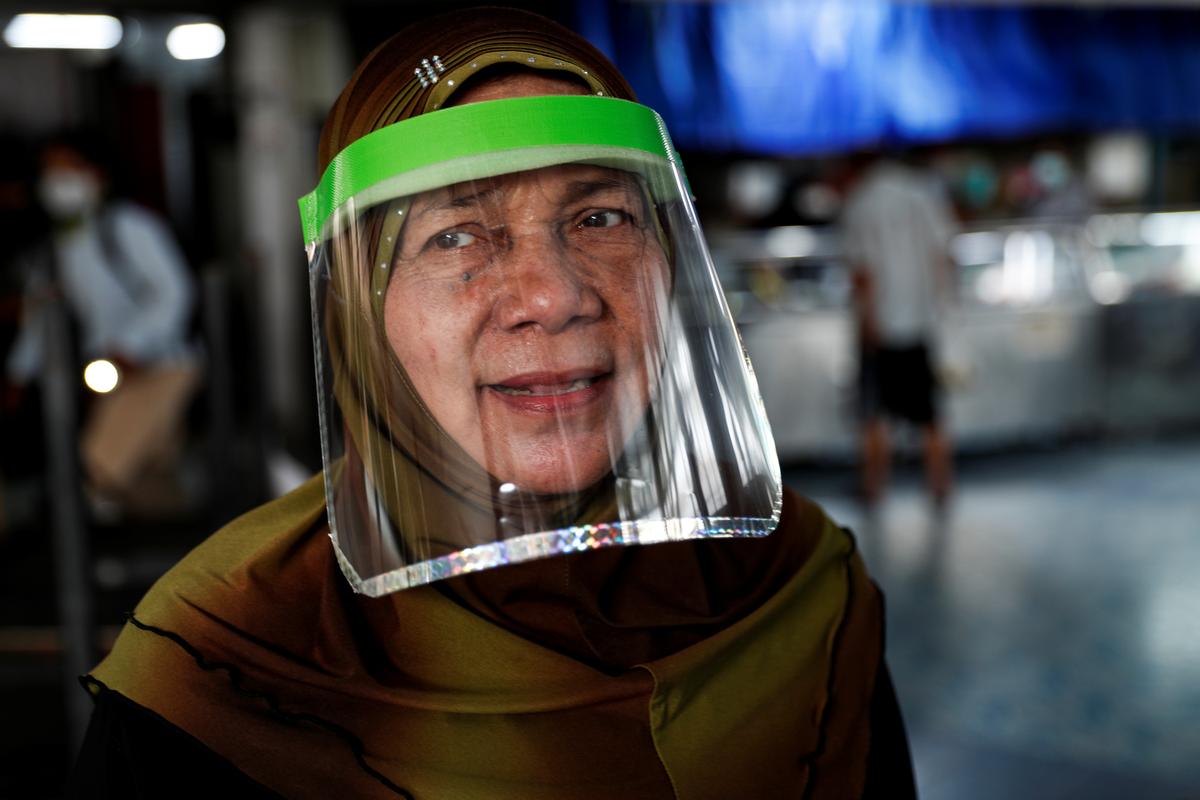 A Muslim woman wearing a face shield reacts upon arriving at a mosque before Friday prayer on the first day of holy fasting month of Ramadan, amid the coronavirus disease (COVID-19) outbreak, in Bangkok, Thailand April 24, 2020. Photo: Reuters