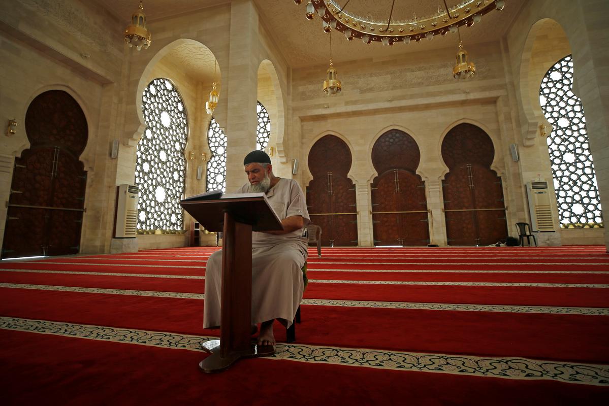 A Palestinian Muazzin, a person who calls for prayers, reads the Koran in an almost empty mosque on the first Friday of the holy fasting month of Ramadan as prayers by worshippers in the holy places are suspended due to concerns about the spread of the coronavirus disease (COVID-19) in the northern Gaza Strip April 24, 2020. Photo: Reuters