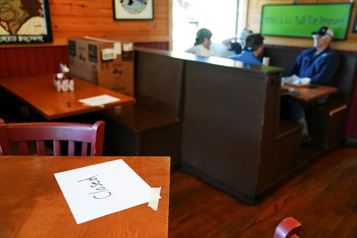 People eat lunch inside Moe's Original BBQ near tables closed for seating as part of social distancing guidelines after it reopened to the public as part of the phased reopening of businesses and restaurants from the coronavirus disease (COVID-19) restrictions in Atlanta, Georgia, U.S. April 27, 2020. Photo: Reuters