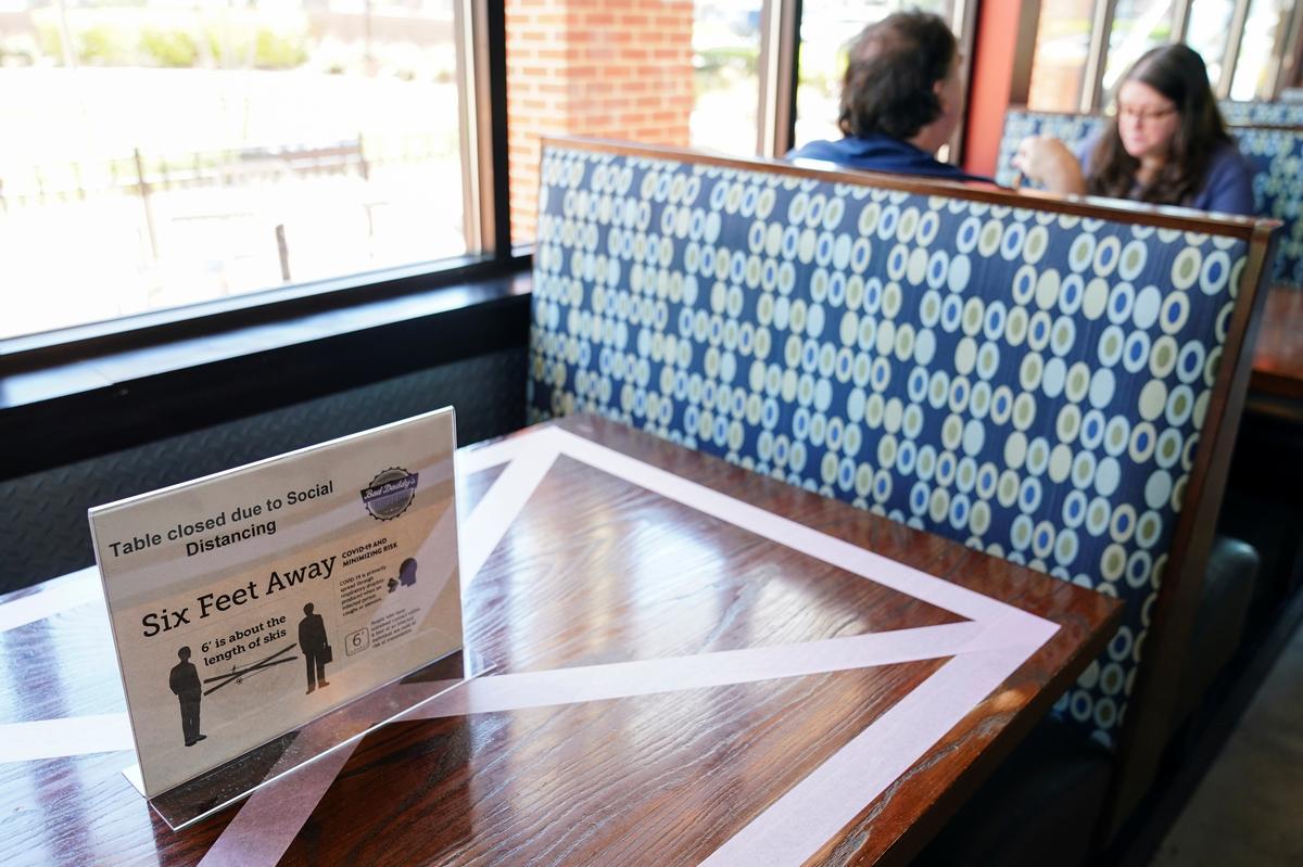 Customers eat lunch next to a table closed for social distancing at Bad Daddy's Burger Bar on the day restaurants and theaters were allowed to reopen to the public as part of the phased reopening of businesses and restaurants from the coronavirus disease (COVID-19) restrictions in Smyrna, Georgia, U.S. April 27, 2020. Photo: Reuters