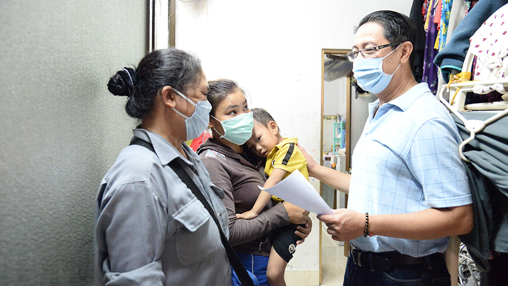 Nguyen Nghiem Quang (right), leader of a civil group in Tan Binh District, Ho Chi Minh City, Vietnam, makes a list of disadvantaged people who need help in his neighborhood to help them access much-needed support. Photo: Tu Trung / Tuoi Tre