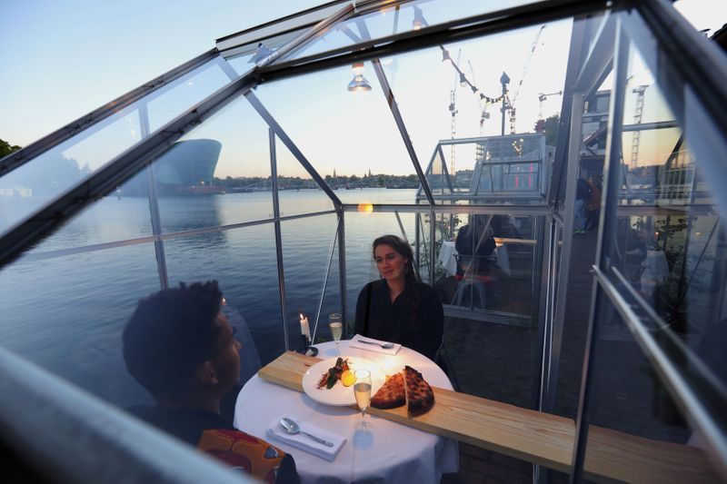 People have meals inside a 'quarantine greenhouse' being tested at a restaurant in Amsterdam. Photo: Reuters