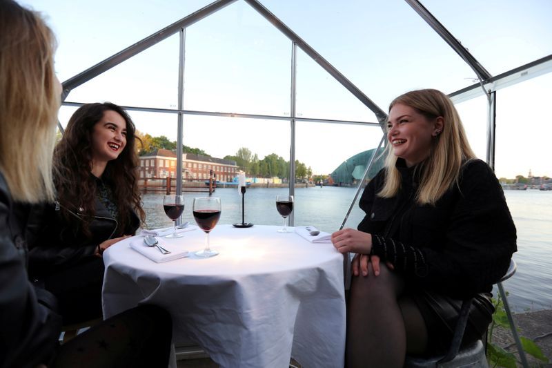 People have meals inside a 'quarantine greenhouse' being tested at a restaurant in Amsterdam. Photo: Reuters