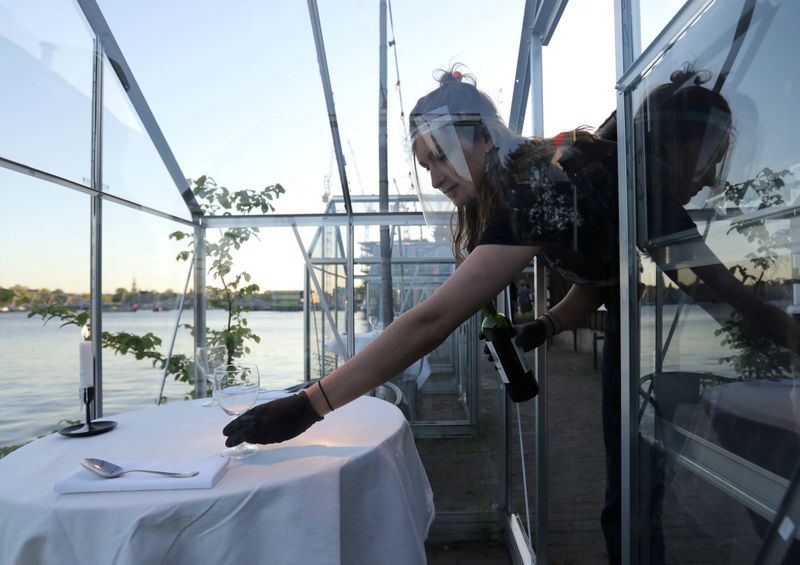 An attendant prepares a table in a 'quarantine greenhouse' being tested at a restaurant in Amsterdam. Photo: Reuters