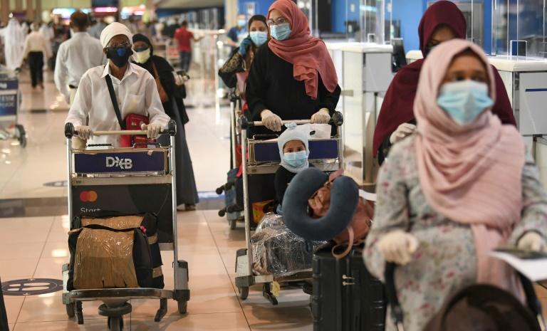 Indian nationals gather at the Dubai International Airport before leaving the Gulf Emirate on a flight back to their country, on May 7, 2020. Photo: AFP