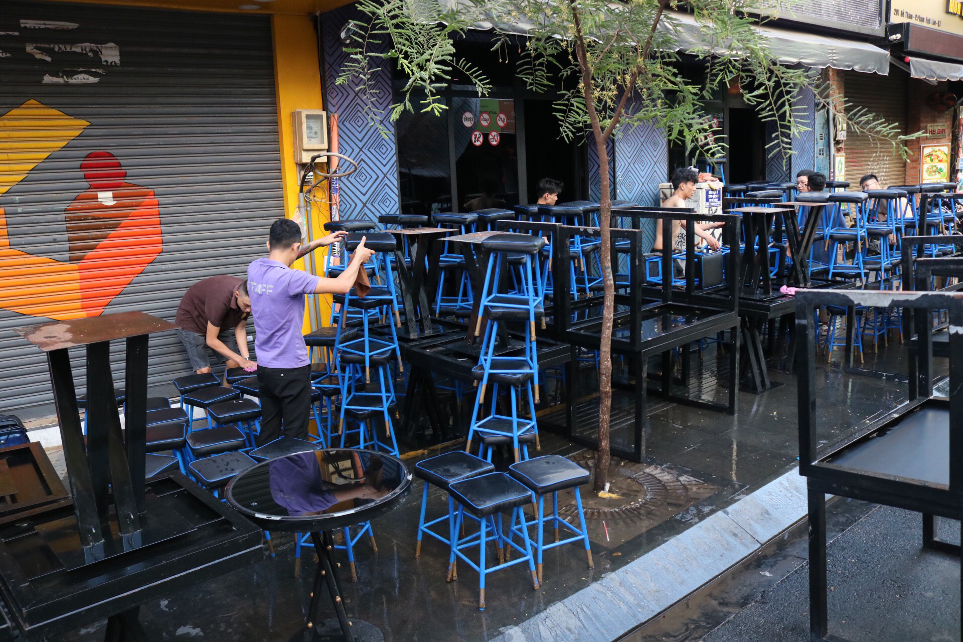 Employees of a business on Bui Vien ‘backpacker’s street’ in District 1, Ho Chi Minh City cleans tables and chairs to prepare for reopening following a closure due to coronavirus disease (COVID-19), May 8, 2020. Photo: Hoang An / Tuoi Tre