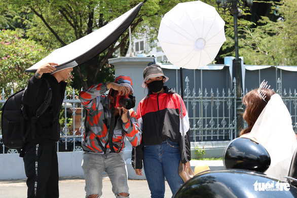 Nguyen The Nha (center) and his team are seen taking pre-wedding photos for a couple in Ho Chi Minh City, Vietnam, May 13, 2020. Photo: Ngoc Phuong / Tuoi Tre