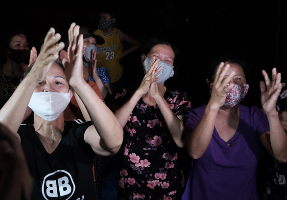 Women clap their hands to celebrate the lift of a COVID-19 lockdown imposed in Ha Loi Village, Me Linh District, Hanoi, Vietnam, May 6, 2020. Photo: Mai Thuong / Tuoi Tre