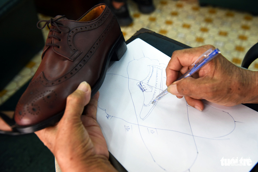 Ngoc sketches shoes on paper before making them by hand. Photo: Duyen Phan / Tuoi Tre