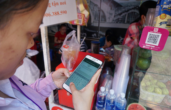 A woman pays for her drink using an e-wallet app in District 1, Ho Chi Minh City in an undated file photo. Photo: Tuyet Kieu / Tuoi Tre