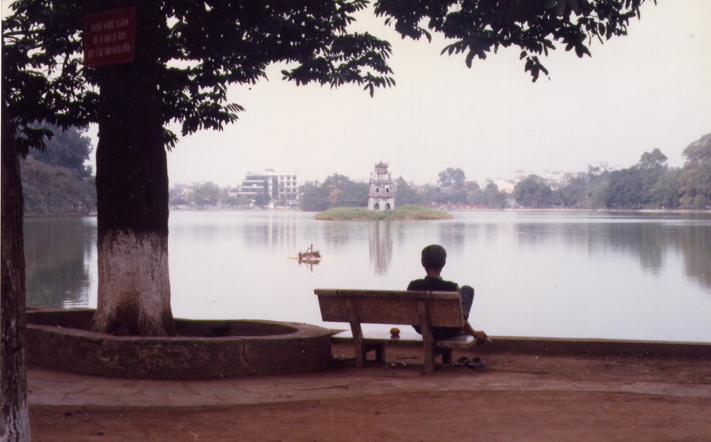 A man sits by Hoan Kiem Lake in Hanoi in 1997. Photo: Kyle Nunas