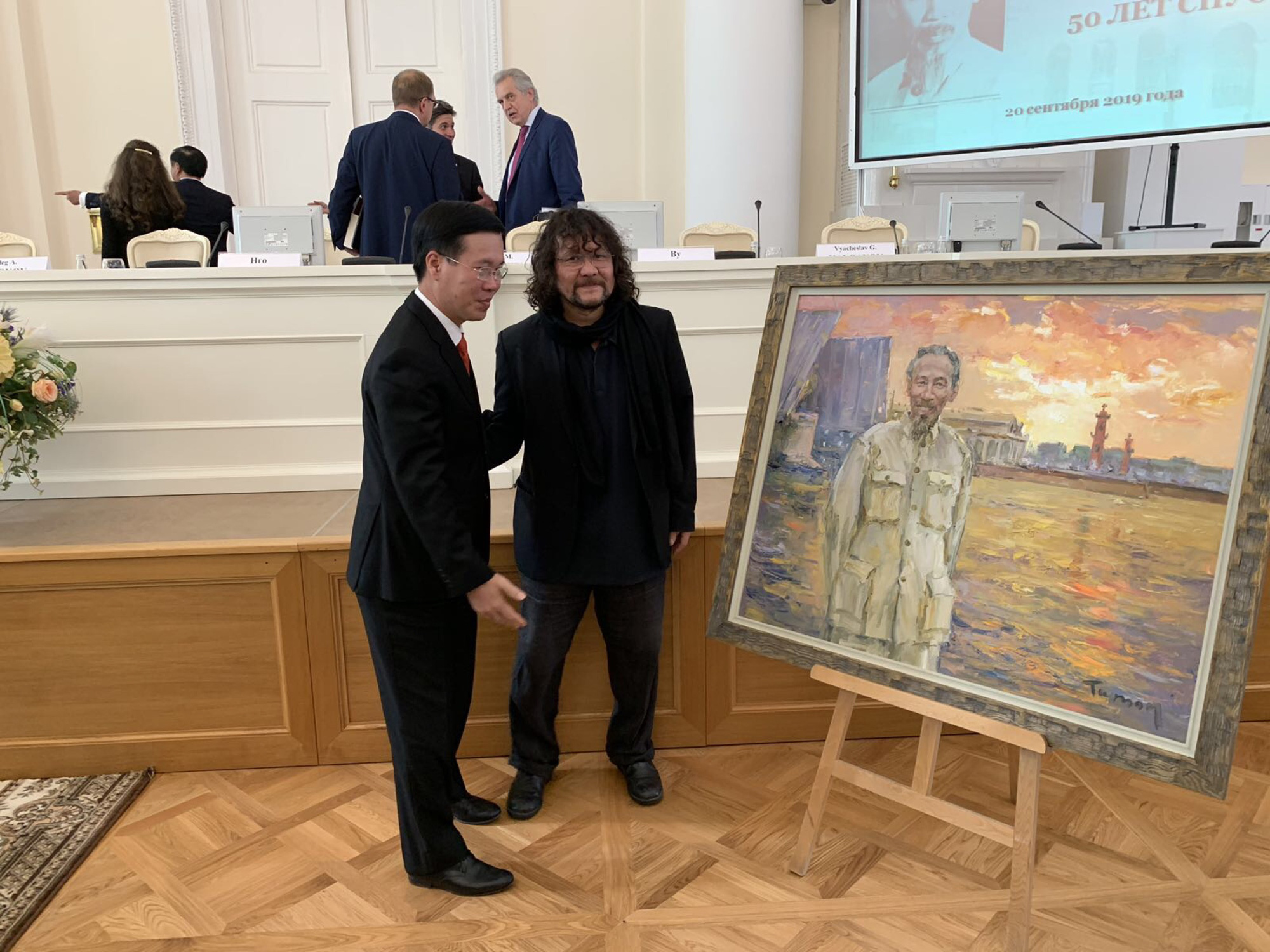 Russian artist Tuman Zhumabaev (right) and Vo Van Thuong, head of the Central Party Committee's Propaganda and Education, stand in front of one of Zhumabaev’s paintings depicting late Vietnamese President Ho Chi Minh, which was presented as a gift to the delegation of Vietnamese leaders during their visit to Russia in this photo captured on February 20, 2019 and provided by Lilac gallery.