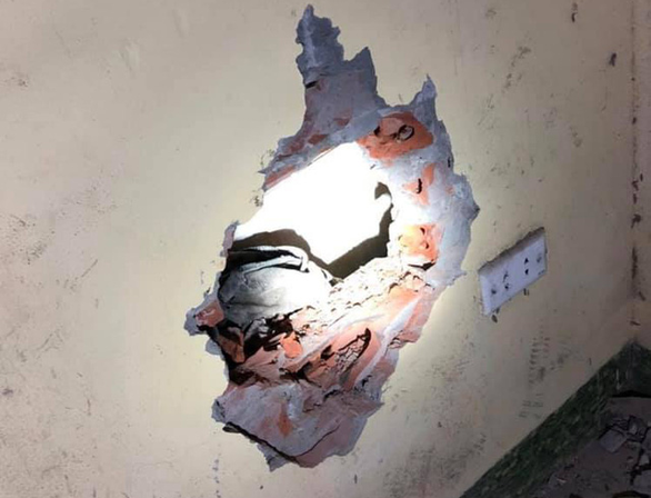 This supplied photo shows a hole opened up on a wall for rescuers to remove a child abandoned in a narrow gap between two houses in Gia Lam District, Hanoi, August 18, 2020