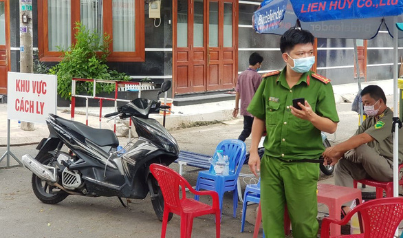 Police and militia officers guard a neighborhood in Hoa Thanh Ward, Tan Phu District, Ho Chi Minh City after a recovered COVID-19 patient who lives there retested positive. Photo: Ngoc Khai / Tuoi Tre