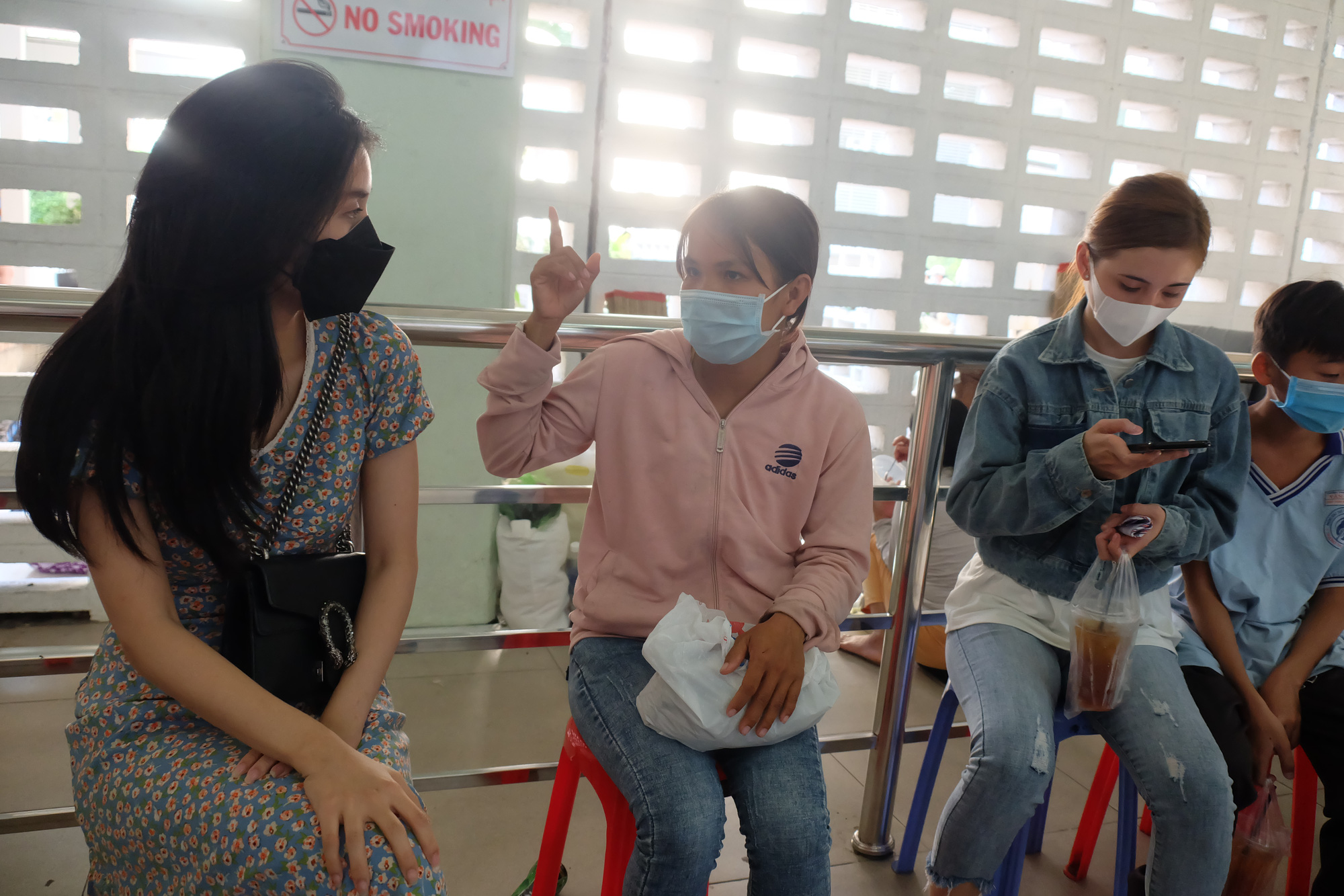 Nguyen Do Truc Phuong (left) visits Cho Ray Hospital in Ho Chi Minh City where Phan Van Tam is treated for a king cobra bite to meet his wife Bui Thi Ngoc Tuoi (second left). Photo: Vu Thuy / Tuoi Tre