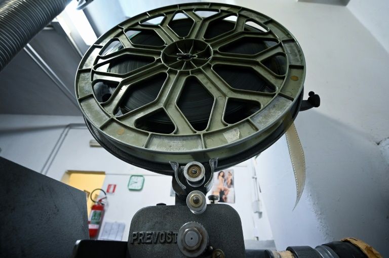 A view taken on August 26, 2020 shows a film reel attached to a projector in the projection room of the 'Ambasciatori' (The Ambassadors), Rome's last porn cinema theater. Photo: AFP
