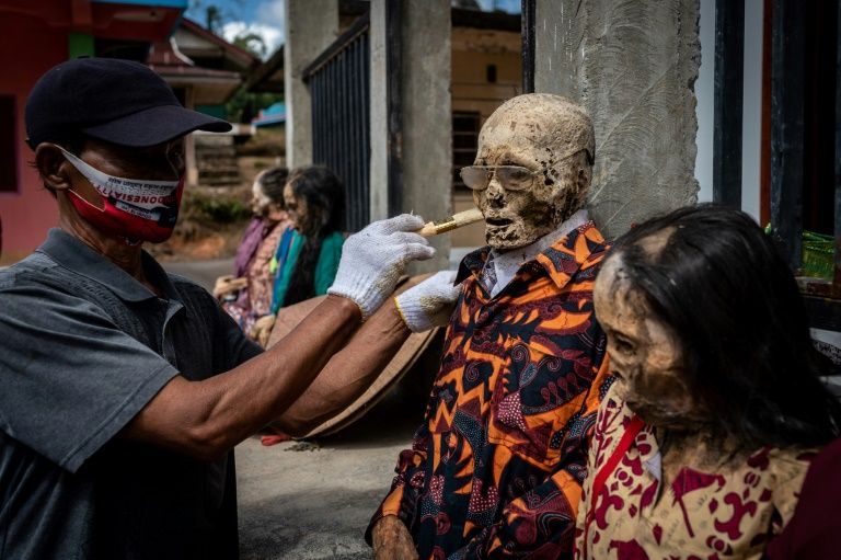 The family members were unearthed and laid out to dry in the sun, before being dressed. Photo: AFP