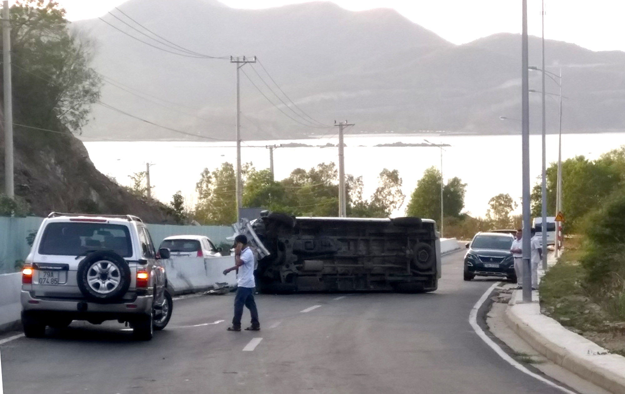 A 16-seat passenger van is on its side after hitting a concrete divider on the Cu Hin mountain pass in Nha Trang City, Khanh Hoa Province, Vietnam, August 30, 2020. Photo: Phan Song Ngan / Tuoi Tre