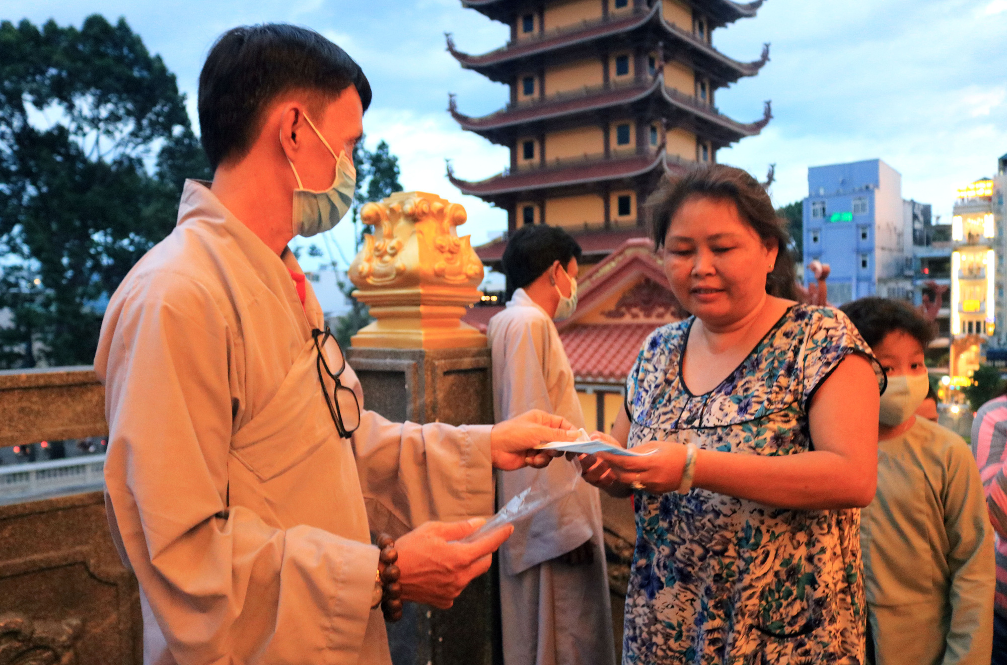 Visitors are handed free face masks when entering Viet Nam Quoc Tu Pagoda amid the novel coronavirus disease (COVID-19) outbreak on Vu Lan Festival in Ho Chi Minh City, Vietnam, September 2, 2020. Photo: Nhat Thinh / Tuoi Tre