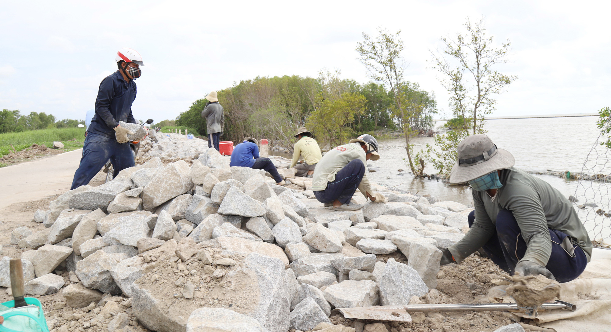 People fortify a section of coastal embankment in Ca Mau Province, Vietnam. Photo: Chi Quoc / Tuoi Tre