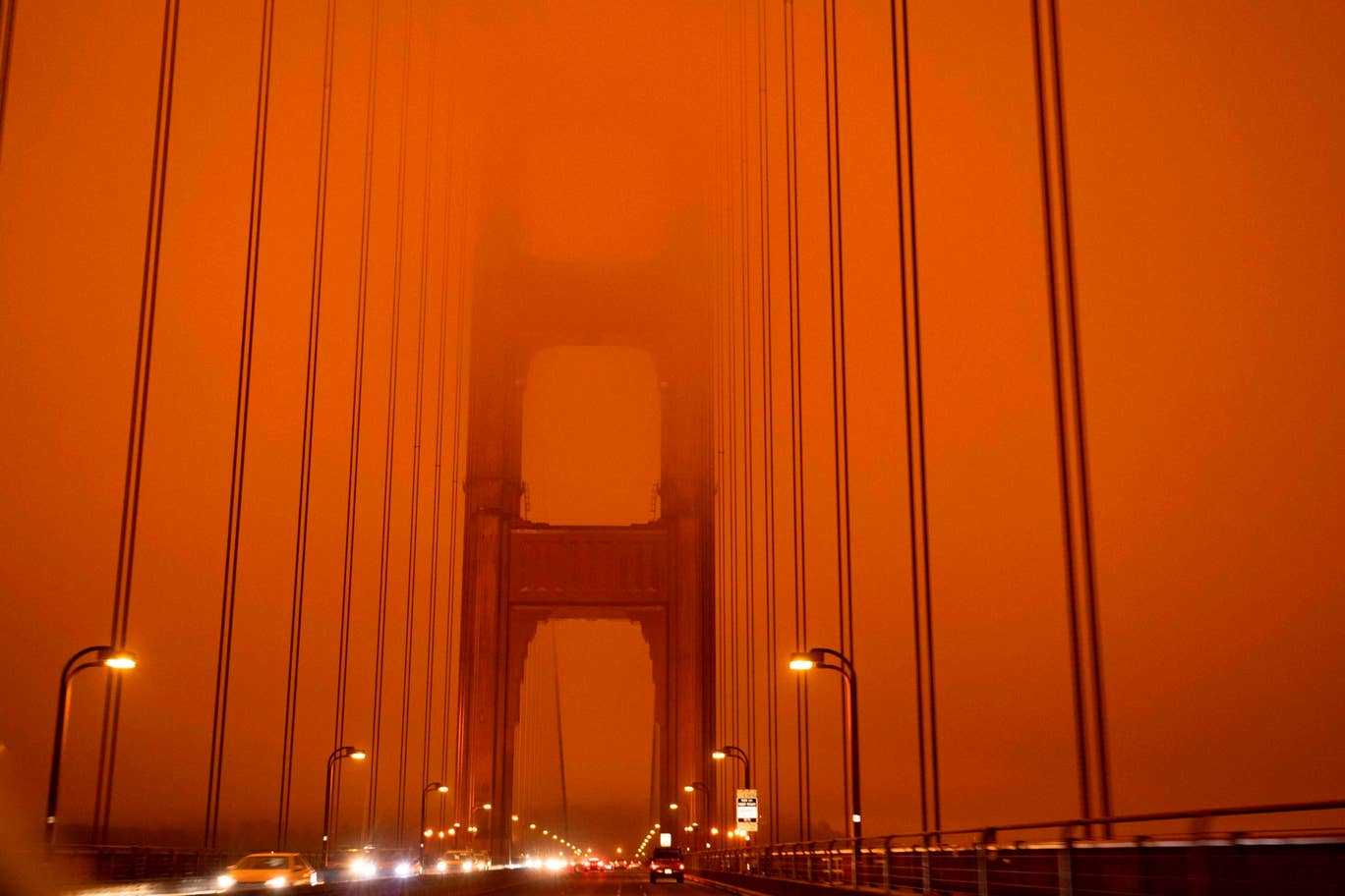 Cars drive along the San Francisco Bay Bridge under an orange smoke filled sky at midday in San Francisco, California on September 9, 2020. Photo: AFP