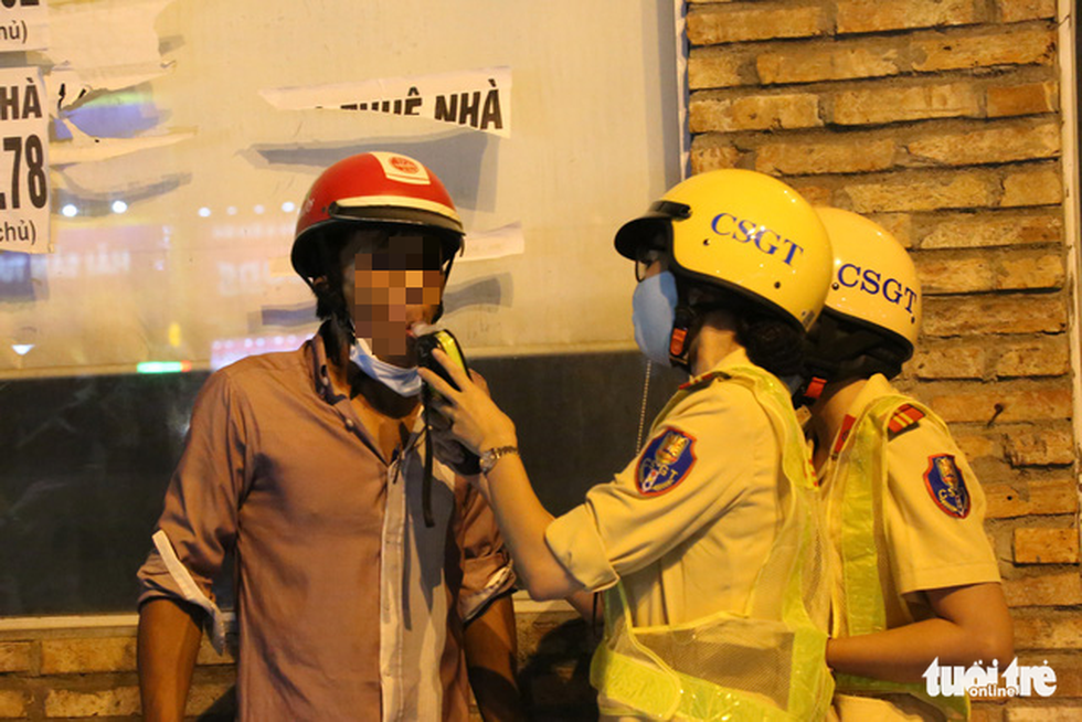 A traffic policewoman measures the breath alcohol concentration of a driver in Ho Chi Minh City, September 9, 2020. Photo: Minh Hoa / Tuoi Tre