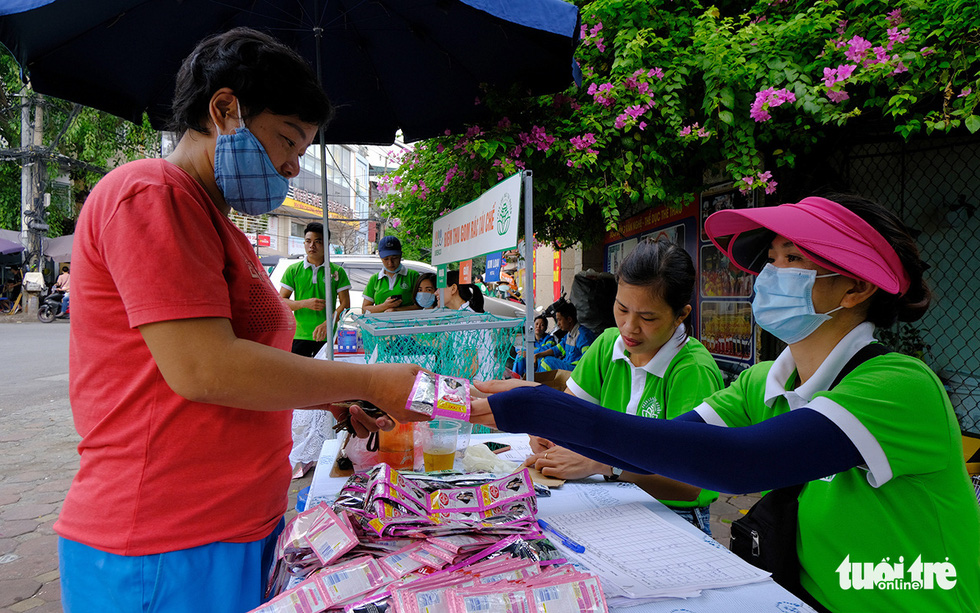 People exchange sorted trash for shampoo and shower gel at an URENCO exchange point in Dong Da District, Hanoi, September 12, 2020. Photo: Ha Thanh / Tuoi Tre
