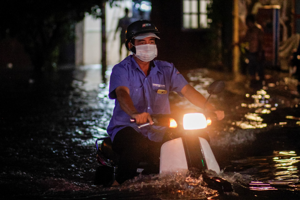 A motorbike travels on a flooded street after a heavy rain in Thu Duc District,  Ho Chi Minh City, September 11, 2020. Photo: Chau Tuan / Tuoi Tre