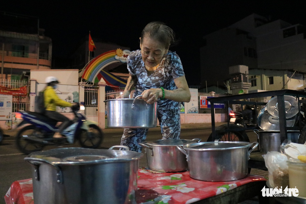 Sau said she suffers from chronic back pain, but the joy of running her nightly stall selling 'chè' (a Vietnamese sweet dessert) helps her overcome the pain. Photo: Ngoc Phuong / Tuoi Tre